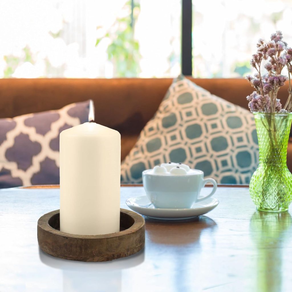 Stonebriar ivory pillar candle styled in a modern bathroom with floating shelves, wood vanity, round mirror, grey bathroom rugs, towels, and spa-inspired decor.