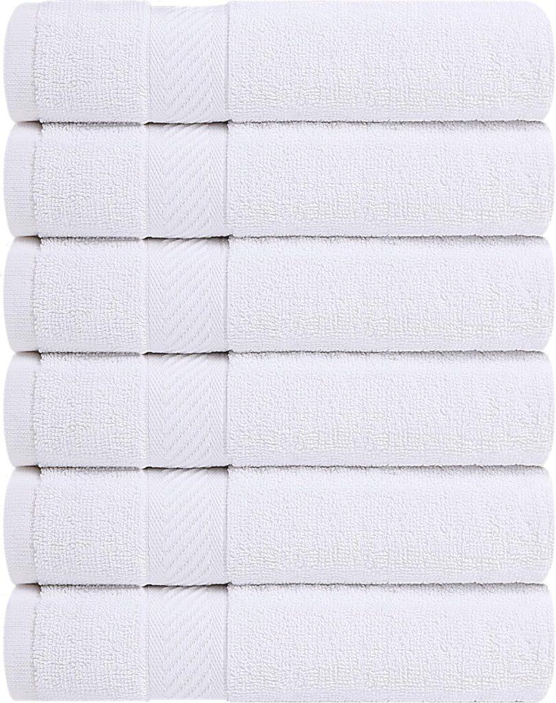 Soft Utopia bath towel set styled in a modern bathroom with floating shelves, wood vanity, round wall mirror, bathroom rug, and neutral spa decor.